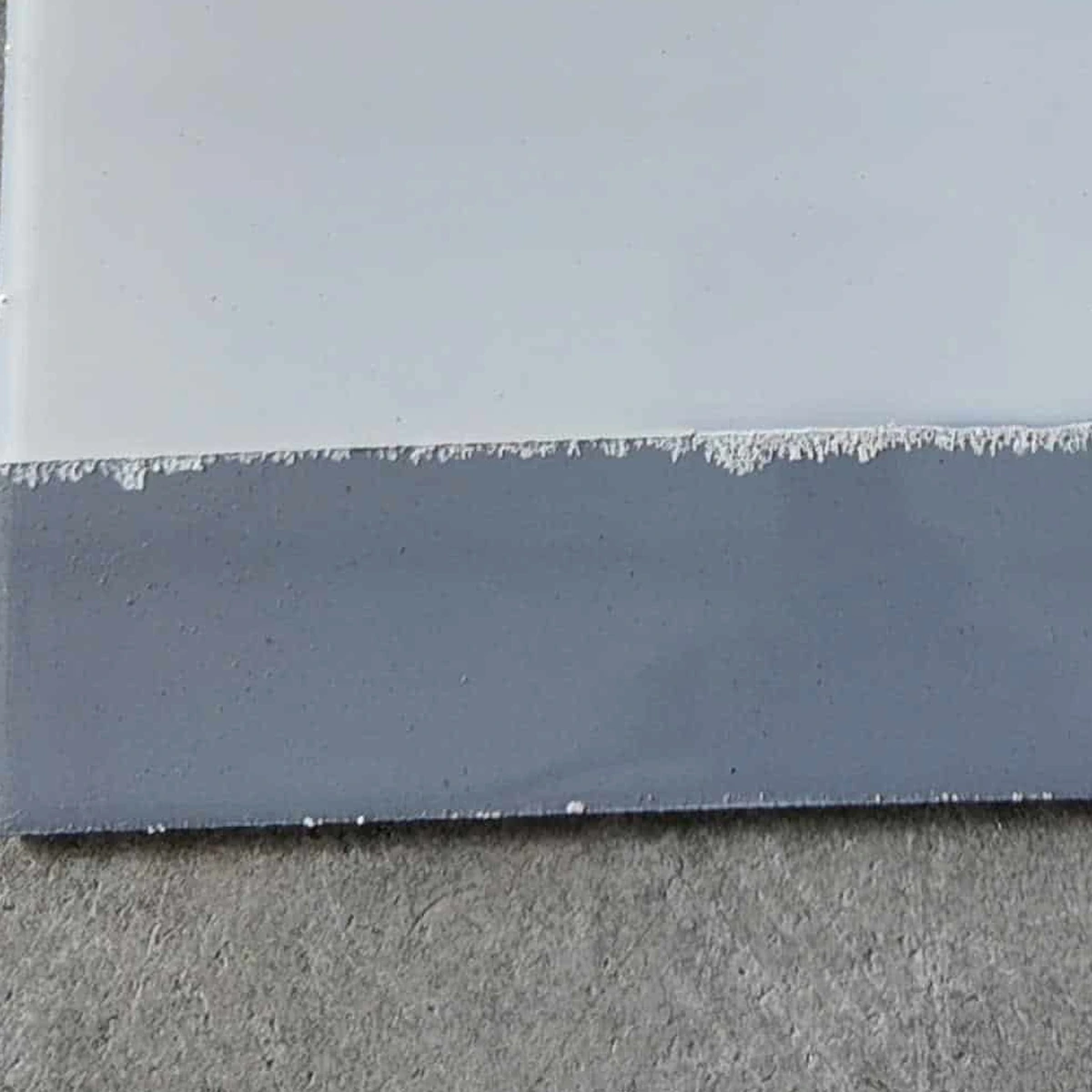Mẫu lót chống rỉ ghi phía dưới lớp phủ trắng trong ảnh thử thực tế Decor Paint