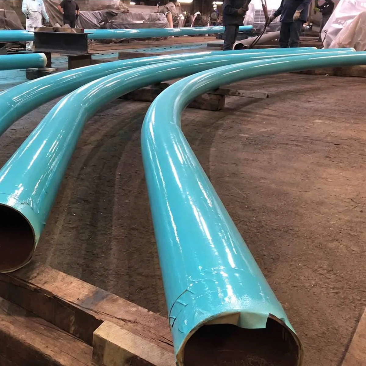 Ảnh thực lớp sơn Epoxy xanh da trời trên các ống thép cong tại xưởng