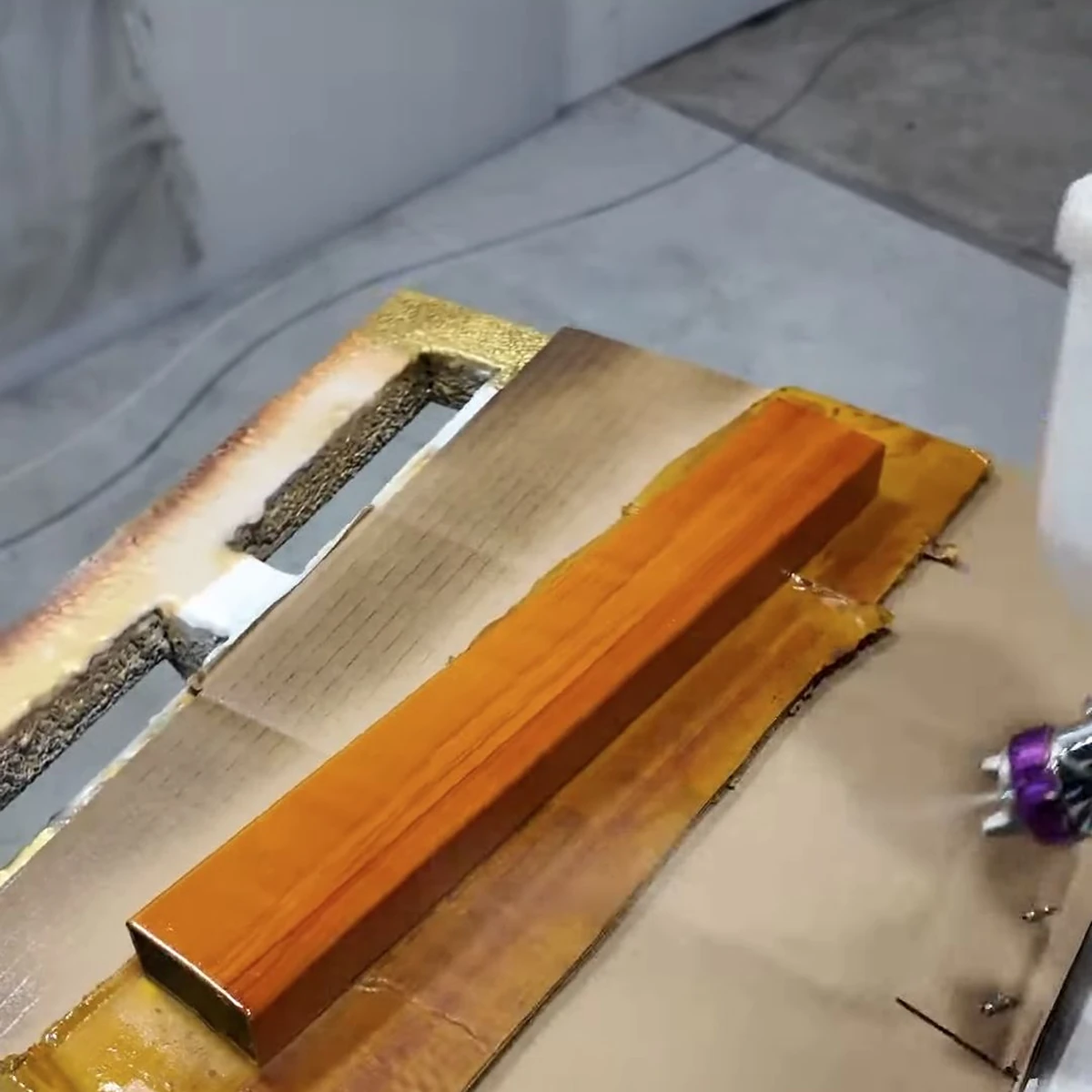 Thanh mẫu vân gỗ sắc hổ phách đặt chéo trong quá trình sơn